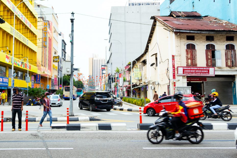 A streetscape with pedestrians, motorcycles, cars, and buses. A Numina sensor is mounted to a pictured light pole, measuring this street in Kuala Lumpur, Malaysia.